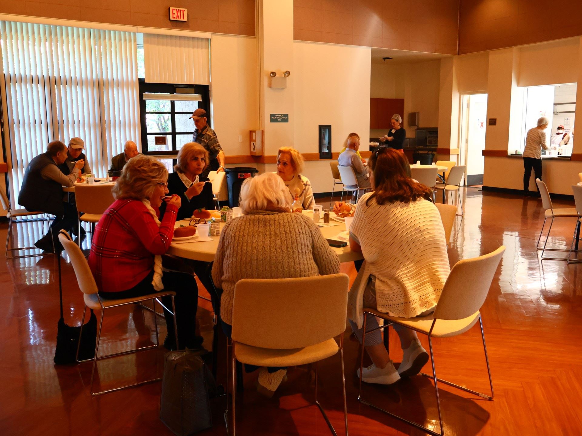 Seniors gathered at tables enjoying a meal from the Senior Nutrition Program